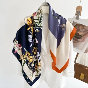Detail of floral silk scarf draped on a white blazer with high-end fashion styling