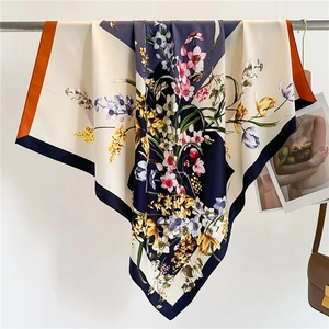 Detail of floral silk square scarf showing botanical print and smooth satin texture