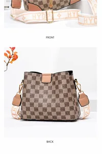 Detailaufnahme der karierten Eimertasche mit breitem Jacquard-Gurt und Metallhaken