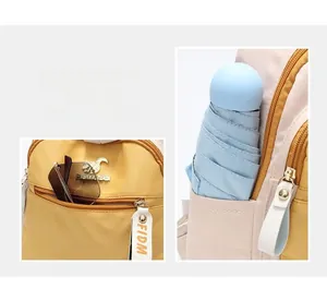 Detail view of yellow nylon backpack with multi-pocket storage and branded metal nameplate