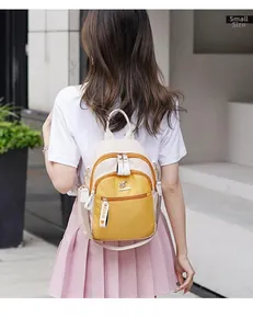 Rear view of model wearing small size yellow and cream backpack with FIDM ribbon detail