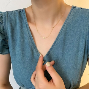 Collier élégant avec pendentifs cœur dorés en acier inoxydable, porté par un mannequin