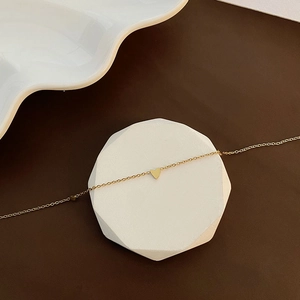 Élégant collier à pendentif cœur doré pour femme sur un support géométrique minimaliste