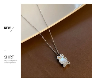 Gros plan du pendentif lapin en argent avec nacre irisée sur une fine chaîne à maillons