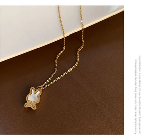 Détail d'un collier pendentif lapin doré avec une texture nacrée en nacre véritable