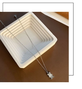 Détail du collier pendentif lapin en argent avec incrustation de nacre sur escalier