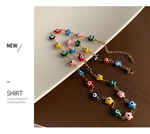 Détail de perles œil grec en forme d'étoile sur une fine chaîne de collier dorée