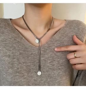 Detail der silbernen Titanstahl Y-Kette mit zwei gravierten runden Anhängern für Damen