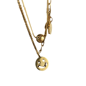 Layered gold smiley face necklace with minimalist snake chain and ball pendant