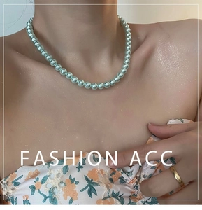 Detalle del collar de perlas naturales verde menta en modelo para un look chic