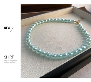 Primer plano detallado de collar de perlas azules con cierre de langosta dorado ajustable
