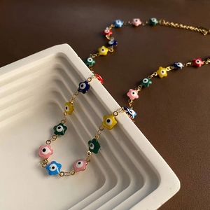 Collier de perles œil grec floral coloré avec chaîne dorée sur plateau blanc