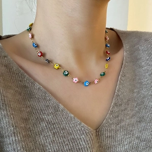 Collier avec pendentifs fleur œil grec en émail coloré et acier titane doré chic