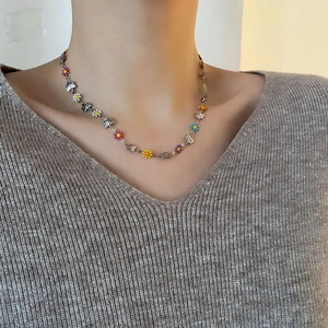 Daisy butterfly titanium steel necklace with colorful enamel flowers on a female model