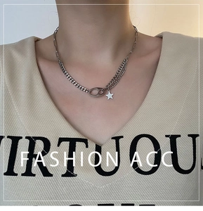 Detail of silver titanium steel layered chain necklace with star and oval link pendants
