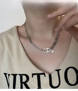 Detail shot of silver pig nose chain necklace with star pendant on a model neck