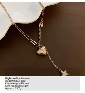 Detailed macro view of gold-tone titanium steel necklace with star and heart charms