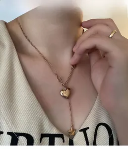 Detail of rose gold double layer heart and star necklace worn on model for fashion look