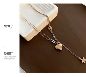 Detail view of double-layer rose gold heart and star pendants on mixed link chain