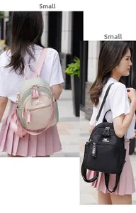 Close-up of small nylon backpack with golden kangaroo logo and FIDM letter pendant