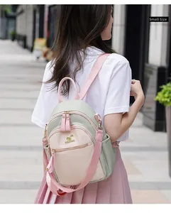 Rear view of a model wearing a small-size contrast color backpack in green and pink