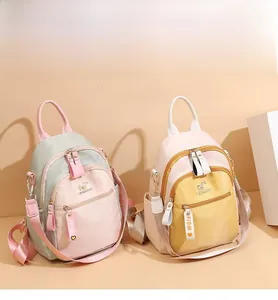 Detail view of mini backpacks in pink and yellow with FIDM ribbon zipper and multi-pockets