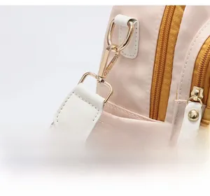Detail of the pale gold detachable hardware hook on the bicolor fashion backpack