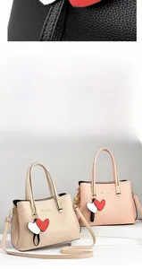 Close-up of lychee grain faux leather texture and golden metal logo on elegant tote bags