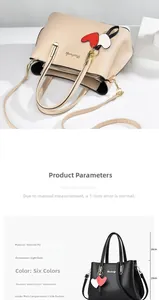 Detail view of the PU leather handbag's interior pockets and heart pendant accessory