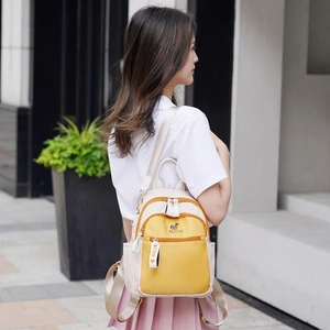 Women's minimalist color-block backpack in beige and yellow with decorative ribbons