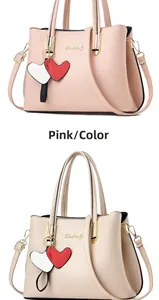 Detail view of pink and beige lychee pattern handbags with metal handles and heart charm