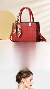 Detail of red croc-embossed handbag with woven handle, decorative silk scarf and strap