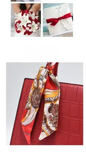Detail of red croc-embossed handbag with elegant floral silk scarf tied to handle