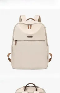 Close-up of beige waterproof backpack with premium brown leather handle and metal logo