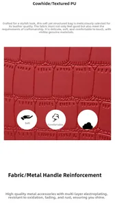 Close-up of red crocodile texture handbag with gold hardware and reinforced handle
