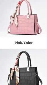 Detail of crocodile embossed leather handbag with woven handle and silk scarf accessory