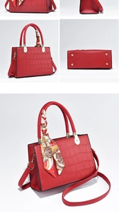 Detail of red croc-embossed handbag with silk scarf, gold hardware and protective feet