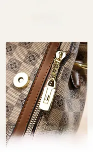 Detail of the golden zipper slider and chain on the vintage patterned canvas handbag