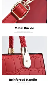 Close-up of crocodile textured red handbag with gold hardware and woven handle detail