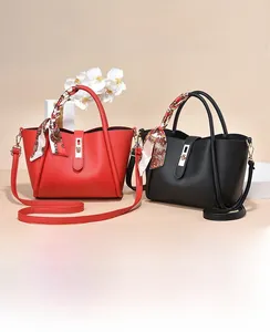 Détail de sacs à main en rouge et noir avec texture grainée et foulards en soie décoratifs