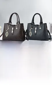 Dettaglio di borse di lusso in pelle monogramma marrone e nera con ciondoli a foglia