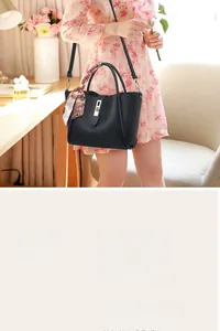 Détail du sac à main en cuir noir grainé avec foulard décoratif et fermoir métallique