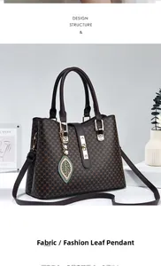 Dettaglio borsa marrone monogram con chiusura dorata e pendente a foglia con perla