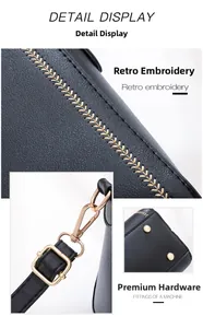 Detail of black pebbled leather bag with yellow embroidery and gold-tone metal hardware