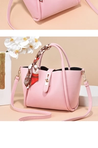 Détail de la texture cuir grainé et du foulard en soie sur le sac à main rose