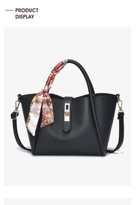 Détail du sac à main en cuir grainé noir avec fermoir doré et foulard en soie