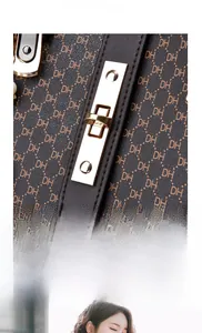 Dettaglio borsa monogramma marrone con elegante chiusura dorata e decoro in perle