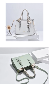 Close-up of minimalist crossbody bag featuring decorative silk scarf and heart print
