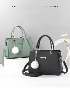 Detailansicht eleganter Handtaschen in Grün und Schwarz auf Displays mit Blumendekor