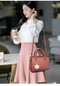 Rosa Damenhandtasche mit weißem Fellbommel und goldenem Markenlogo zum Umhängen